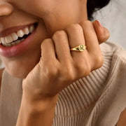 Close-up of a woman model wearing a 14k gold filled signet ring with a leo zodiac symbol on a neutral background